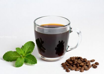 A cup of coffee on an office desk next to a laptop representing mental focus and alertness